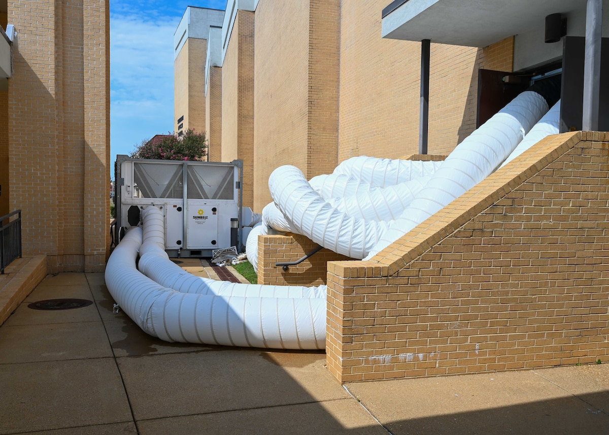 Ducts from a portable HVAC unit run into Squadron Officer School’s Polifka Auditorium, at Maxwell Air Force Base, Ala., Thursday Aug. 21, 2025. Temporary systems are being used to maintain cooling after multiple chiller failures on base.  (U.S. Air Force photo by Senior Airman Tanner Doerr)