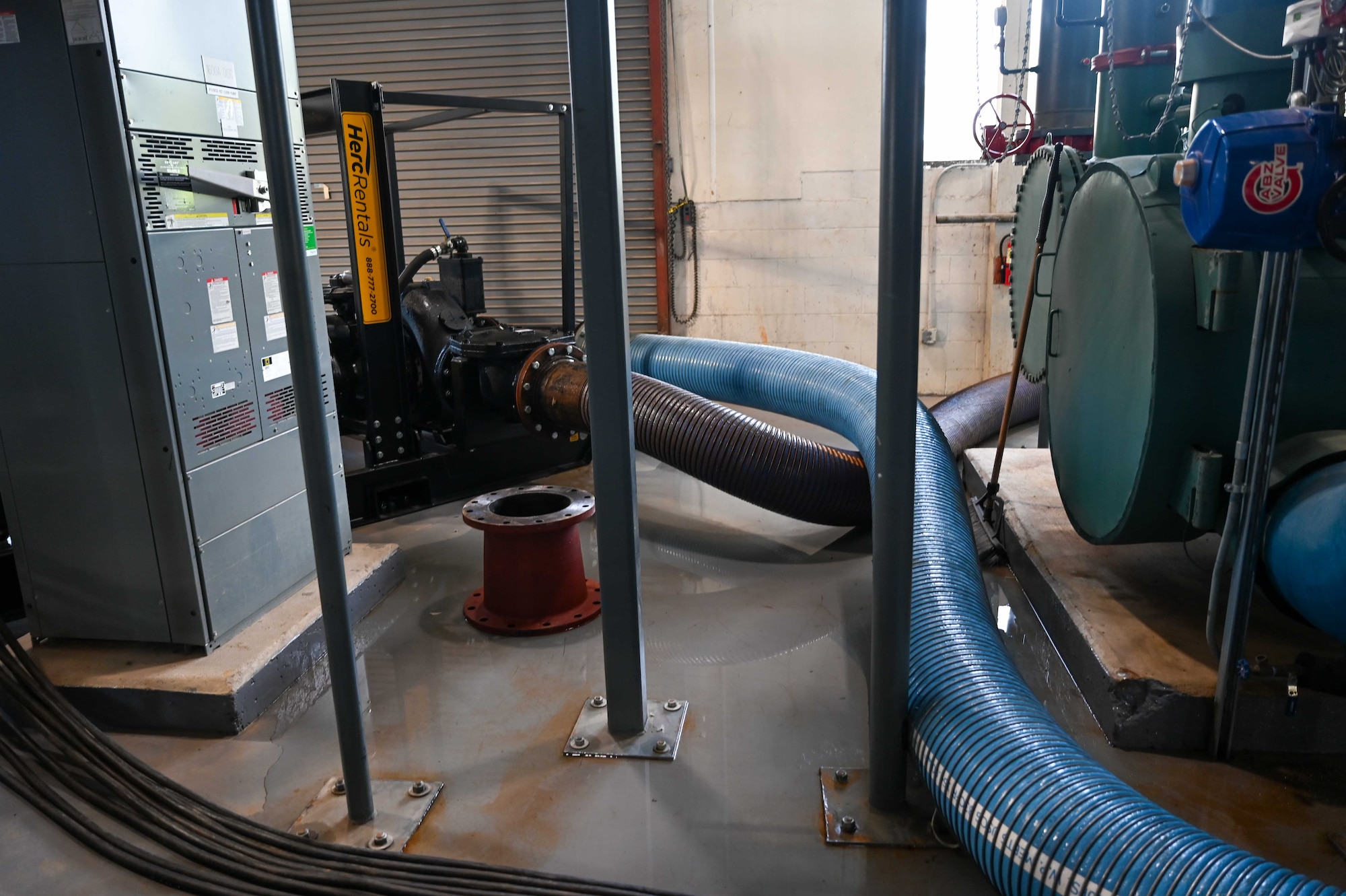 Pipes run from a temporary pump into the base infrastructure at the Building 1410 chiller plant, at Maxwell Air Force Base, Ala., Thursday, Aug. 21, 2025. This temporary system supports cooling operations during maintenance on permanent equipment. (U.S. Air Force photo by Senior Airman Tanner Doerr)