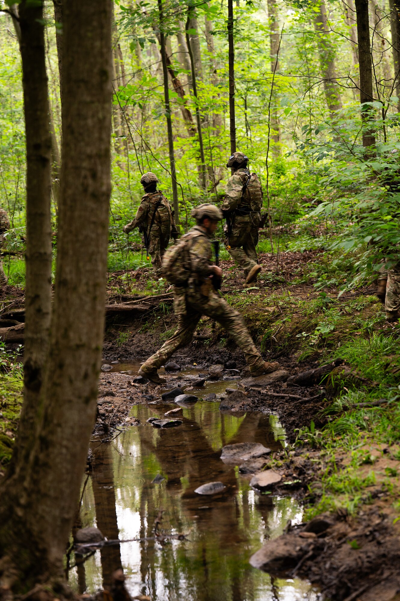 military members travel through forest