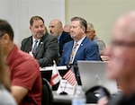 A room full of conference attendees listening to a presentation.