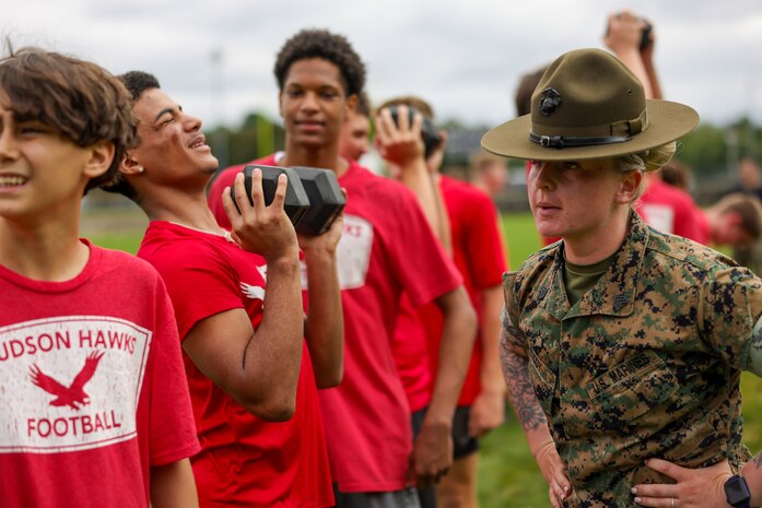 U.S. Marine Corps Sgt. Shannon Ruddy, a drill instructor with Mike Company, 3rd Recruit Training Battalion, Marine Corps Recruit Depot Parris Island, and a native of Blairstown, New Jersey, directs Hudson High School football players during the Marine Corps combat fitness test as part of Marine Week Boston, Aug. 21, 2025. During Marine Week Boston, Marines with Marine Corps Recruiting Command shared Marine Corps traditions with local high schools in honor of the Corps’ 250th birthday. Marines stationed across the globe commemorate the 250th anniversary of the Marine Corps, honoring a distinguished legacy of service, sacrifice, and unwavering fidelity to both the nation and fellow Marines. (U.S. Marine Corps photo by Sgt. Aidan Hekker)