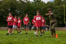 U.S. Marine Corps Sgt. Julie Leon, left, a drill instructor Golf Company, 2nd Recruit Training Battalion, Marine Corps Recruit Depot Parris Island, and a Los Angeles, California native, directs a Hudson High School football player during the Marine Corps combat fitness test as part of Marine Week Boston, Aug. 21, 2025. During Marine Week Boston, Marines with Marine Corps Recruiting Command shared Marine Corps traditions with local high schools in honor of the Corps’ 250th birthday. Marines stationed across the globe commemorate the 250th anniversary of the Marine Corps, honoring a distinguished legacy of service, sacrifice, and unwavering fidelity to both the nation and fellow Marines. (U.S. Marine Corps photo by Sgt. Aidan Hekker)