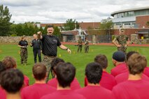 U.S. Marine Corps Gunnery Sgt. Zachary Eaton, the station commander for Recruiting Sub Station Boston, Recruiting Station Boston, gives remarks to the Hudson High School football teams prior to the Marine Corps combat fitness test during Marine Week Boston, Aug. 21, 2025. During Marine Week Boston, Marines with Marine Corps Recruiting Command shared Marine Corps traditions with local high schools in honor of the Corps’ 250th birthday. Marines stationed across the globe commemorate the 250th anniversary of the Marine Corps, honoring a distinguished legacy of service, sacrifice, and unwavering fidelity to both the nation and fellow Marines. (U.S. Marine Corps photo by Sgt. Aidan Hekker)