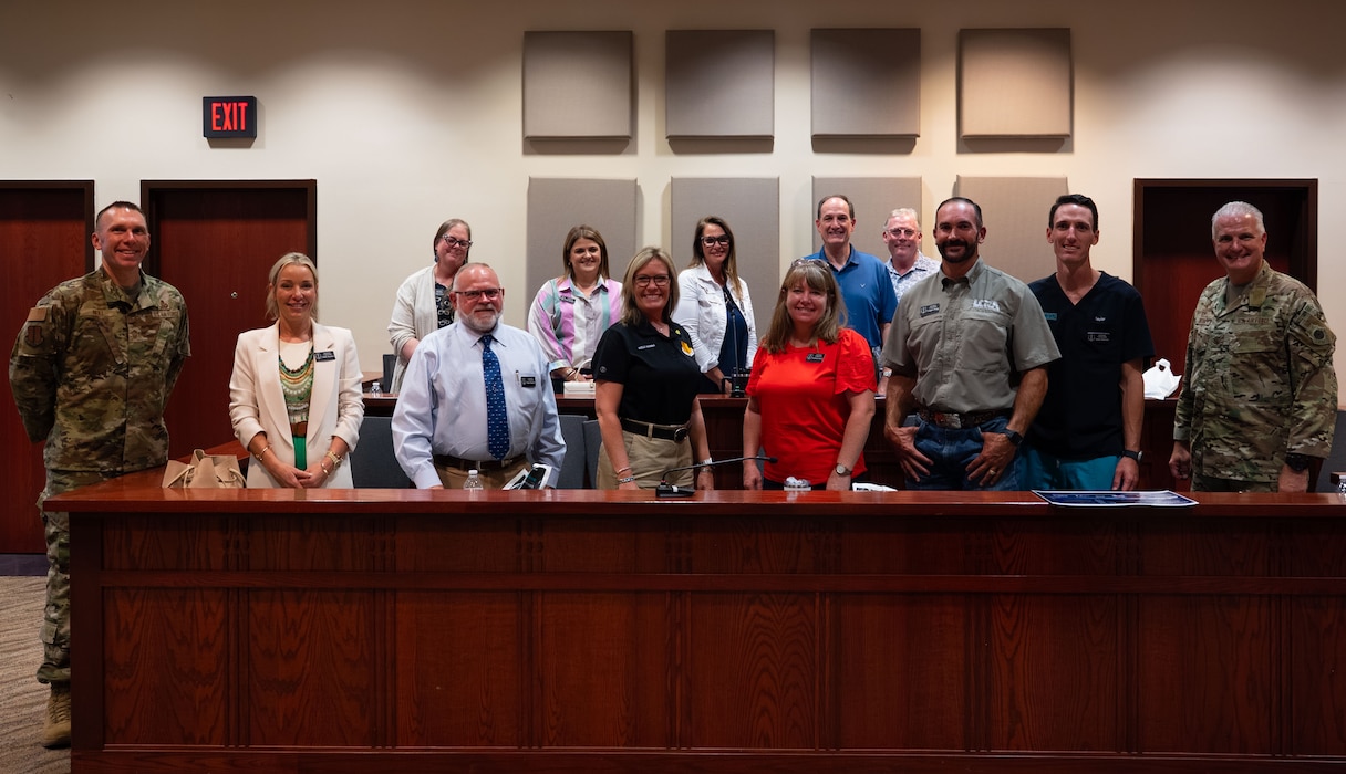 U.S. Air Force Col. Matthew Norton, 17th Training Wing commander, and Chief Master Sgt. Derek Neill, 17th TRW command chief, pose for a group photo with the 2025-2026 honorary commanders during the Wing Staff Agency immersion at the judge advocate court room inside the Norma Brown building, Goodfellow Air Force Base, Texas, Aug. 21, 2025. The WSA immersion was given to explain and showcase the various agencies that support Airmen from the background at Goodfellow. (U.S. Air Force photo by Airman 1st Class Brian Lummus)
