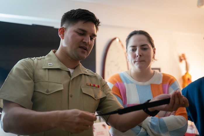 U.S. Marine Corps Capt. Mark Wright, an infantry officer with Special Purpose Marine-Air Ground Task Force-250, showcases how a shirt stay works to volunteers at Christopher’s Haven, a temporary home for families and children receiving cancer treatment, during Marine Week Boston, Aug. 21, 2025. Marine Week Boston provides an opportunity for the Marine Corps to celebrate its 250th Birthday and connect with the community to show support while Christopher's Haven provides a supportive community of temporary apartments for families of children undergoing cancer treatment at nearby hospitals. Wright is a native of Tulsa, Oklahoma. (U.S. Marine Corps photo by Cpl. Vincent Needham)