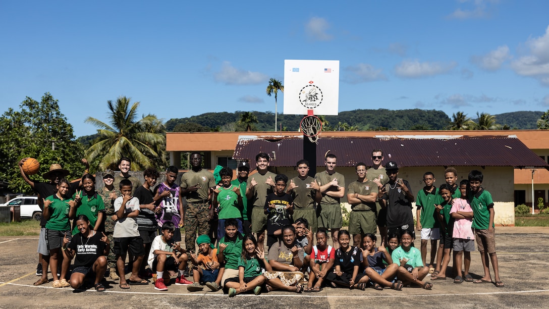 U.S. Marines and sailors with Combat Logistics Battalion 15, Combat Logistics Regiment 17, 1st Marine Logistics Group, pose with local Pohnpeian children for a photo as part of a sports camp during Koa Moana 25 on Pohnpei, Federated States of Micronesia, Aug. 21, 2025.
