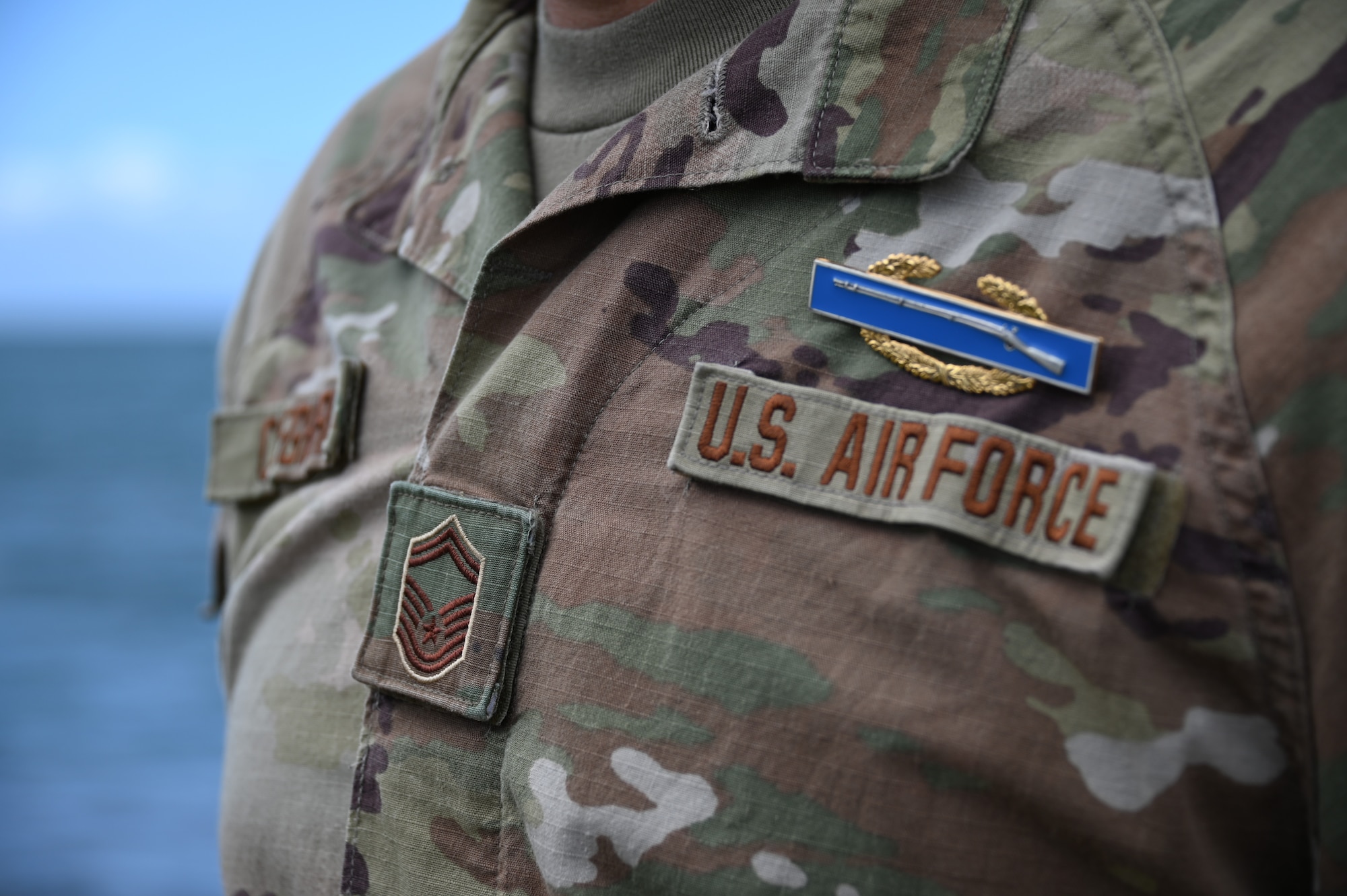 A rifle badge is shown close up on a military uniform.