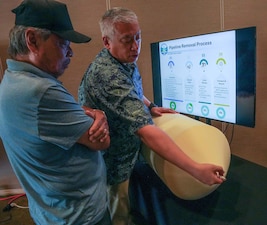 HONOLULU (Aug. 20, 2025) Steven Chow, deputy director for facilities, Navy Closure Task Force-Red Hill (NCTF-RH), explains to a member of the public how pipes at the Red Hill Bulk Fuel Storage Facility (RHBFSF) are cleaned in preparation for removal during the NCTF-RH open house at the Oahu Veterans Center in Honolulu, Aug. 20, 2025. The quarterly open house focused on tank cleaning operations, Tank Closure Plan Supplement 4, environmental remediation and monitoring, and reactivation of the Navy Aiea-Halawa Shaft. Charged with the safe decommissioning of the Red Hill Bulk Fuel Storage Facility RHBFSF, NCTF-RH was established by the Department of the Navy as a commitment to the community and the environment. The Navy continues to engage with the people of Hawaii, regulatory agencies, and other stakeholders as NCTF-RH works to safely and deliberately decommission the RHBFSF. (U.S. Navy photo by Mass Communication Specialist 1st Class Glenn Slaughter)