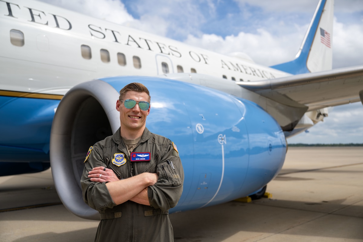 Pilot stands in front of plane.