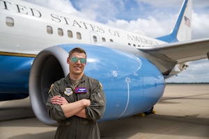 Pilot stands in front of plane.