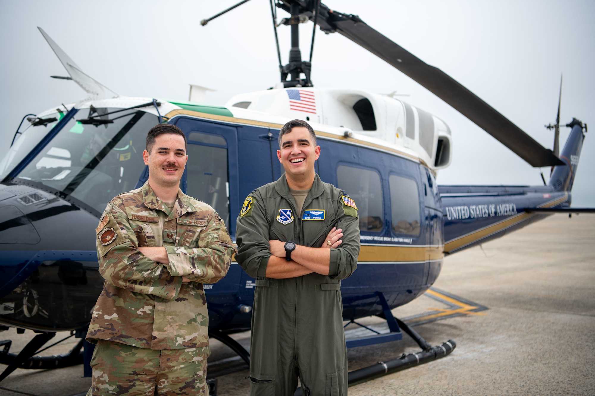 People stand in front of helicopter.