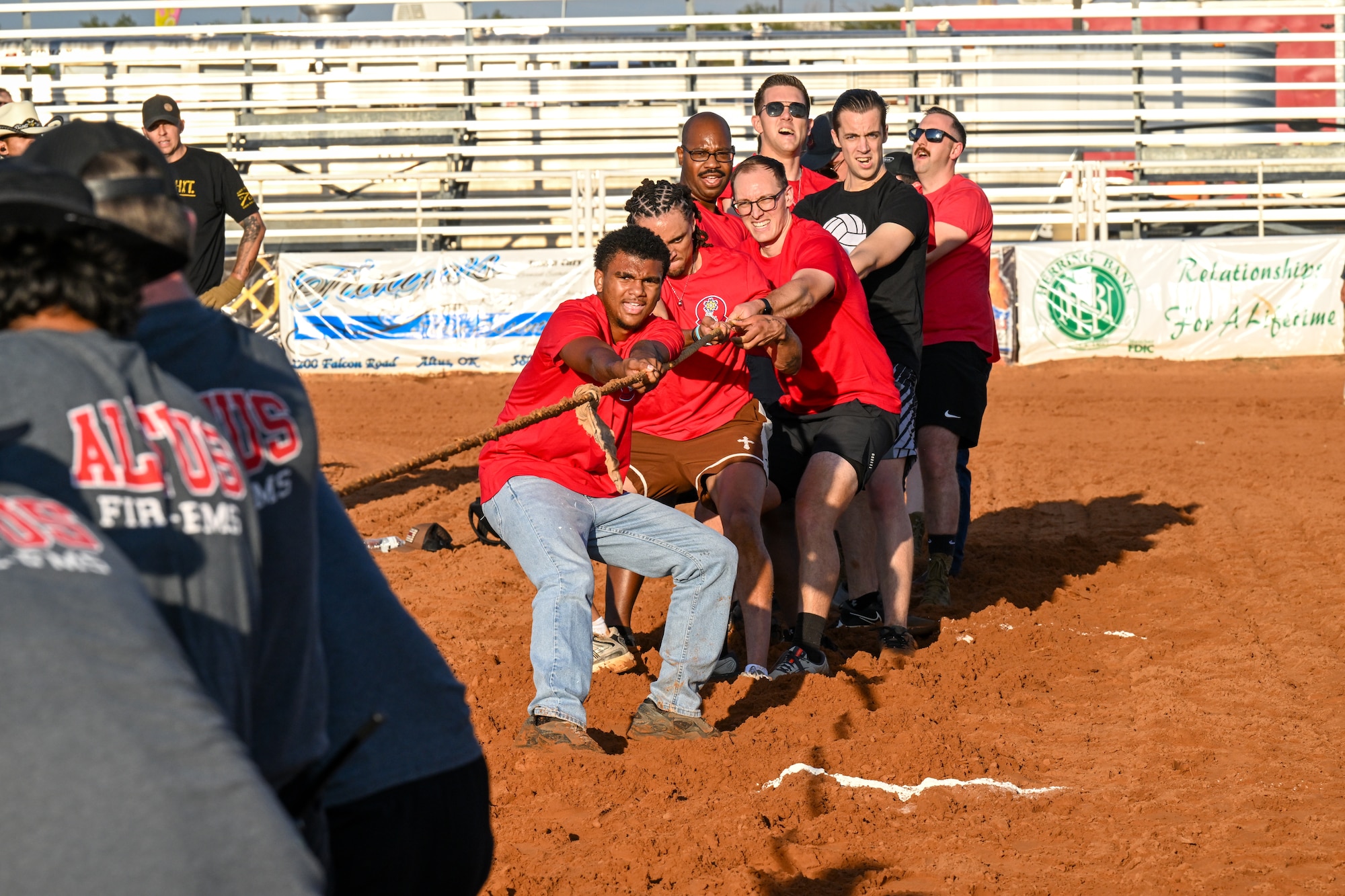 Airmen from the 58th Airlift Squadron battle local Altus Fire and Emergency Medical Services personnel in a Tug-o-War match held at the Great Plains Stampede Rodeo in Altus, Oklahoma, Aug. 21, 2025. The Airmen were matched with the Altus Fire-EMS Department in the event. (U.S. Air Force photo by Airman 1st Class Nathan Langston)