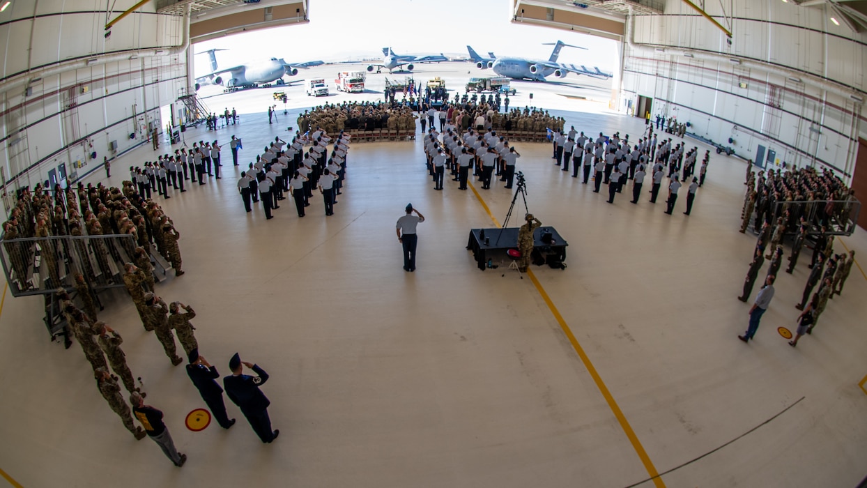 Airmen salute during ceremony