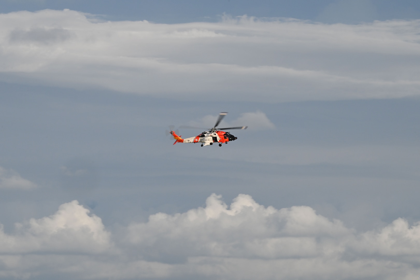 A U.S. Coast Guard Air Station Clearwater MH-60 Jayhawk aircrew flies through the sky during training in Sand Key, Florida, Aug. 13, 2025. U.S. Coast Guard Southeast District units train regularly to stay “semper paratus” or always ready year round. (U.S. Coast Guard photo by Petty Officer 1st Class Riley Perkofski)
