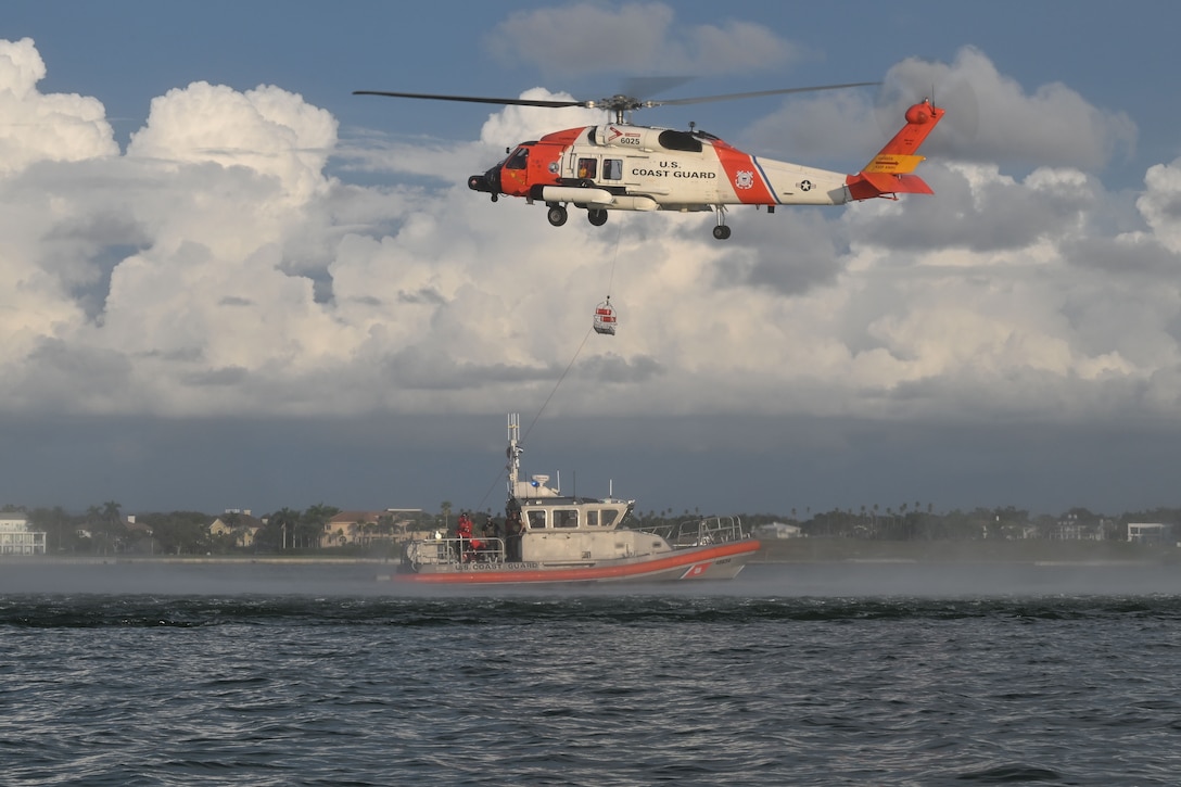 A U.S. Coast Guard Air Station Clearwater MH-60 Jayhawk aircrew deploys a rescue basket to a U.S. Coast Guard Station Sand Key 45-foot response boat-medium boat crew in Sand Key, Florida, Aug. 13, 2025. U.S. Coast Guard Sector St. Petersburg aircrews and boat crews regularly conduct rescue basket hoist training to maintain operational readiness. (U.S. Coast Guard photo by Petty Officer 1st Class Riley Perkofski)