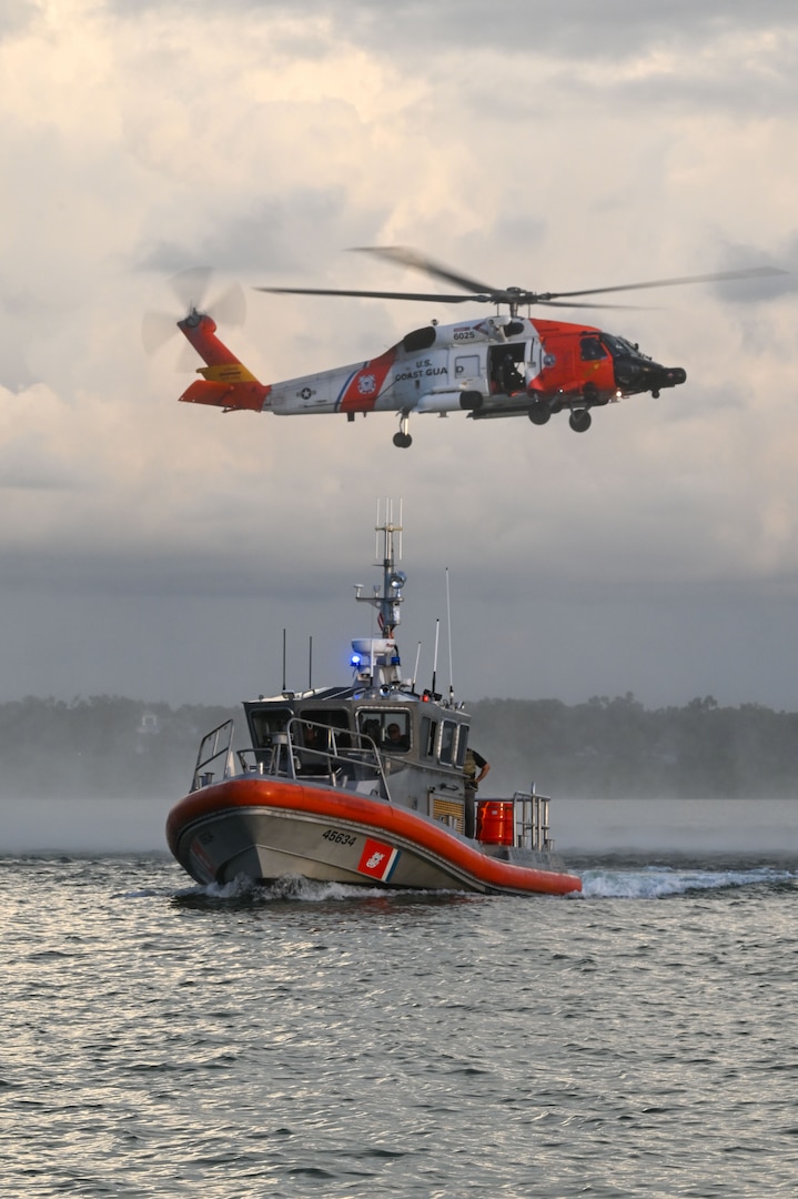 A U.S. Coast Guard Air Station Clearwater MH-60 Jayhawk aircrew flies behind a U.S. Coast Guard Station Sand Key 45-foot response boat-medium boat crew during training in Sand Key, Florida, Aug. 13, 2025. U.S. Coast Guard Station Sand Key has an area of responsibility that extends from Aripeka to Johns Pass Florida. (U.S. Coast Guard photo by Petty Officer 1st Class Riley Perkofski)