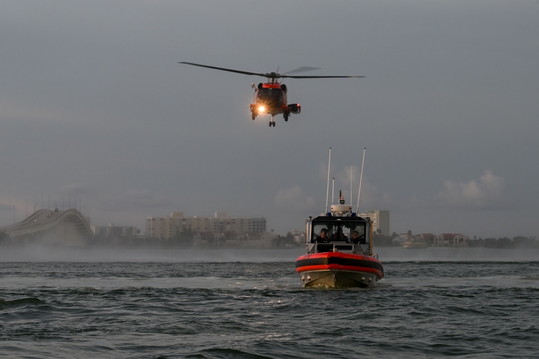 A U.S. Coast Guard Air Station Clearwater MH-60 Jayhawk aircrew flies behind a U.S. Coast Guard Station Sand Key 29-foot response boat-small boat crew during training in Sand Key, Florida, Aug. 13, 2025. U.S. Coast Guard Sector St. Petersburg boatcrews regularly hold hoist training with Air Station Clearwater aircrews to maintain their qualifications and crew readiness. (U.S. Coast Guard photo by Petty Officer 1st Class Riley Perkofski)