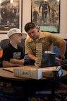 U.S. Marine Corps Capt. Mark Wright, an infantry officer with Special Purpose Marine-Air Ground Task Force-250, plays Jenga with a child at Christopher’s Haven, a temporary home for families and children receiving cancer treatment, during Marine Week Boston, Aug. 21, 2025. Marine Week Boston provides an opportunity for the Marine Corps to celebrate its 250th Birthday and connect with the community to show support while Christopher's Haven provides a supportive community of temporary apartments for families of children undergoing cancer treatment at nearby hospitals. Wright is a native of Tulsa, Oklahoma. (U.S. Marine Corps photo by Cpl. Vincent Needham)