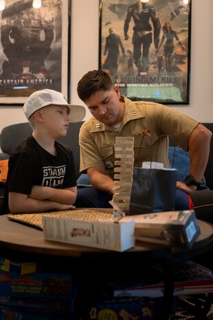 U.S. Marine Corps Capt. Mark Wright, an infantry officer with Special Purpose Marine-Air Ground Task Force-250, plays Jenga with a child at Christopher’s Haven, a temporary home for families and children receiving cancer treatment, during Marine Week Boston, Aug. 21, 2025. Marine Week Boston provides an opportunity for the Marine Corps to celebrate its 250th Birthday and connect with the community to show support while Christopher's Haven provides a supportive community of temporary apartments for families of children undergoing cancer treatment at nearby hospitals. Wright is a native of Tulsa, Oklahoma. (U.S. Marine Corps photo by Cpl. Vincent Needham)
