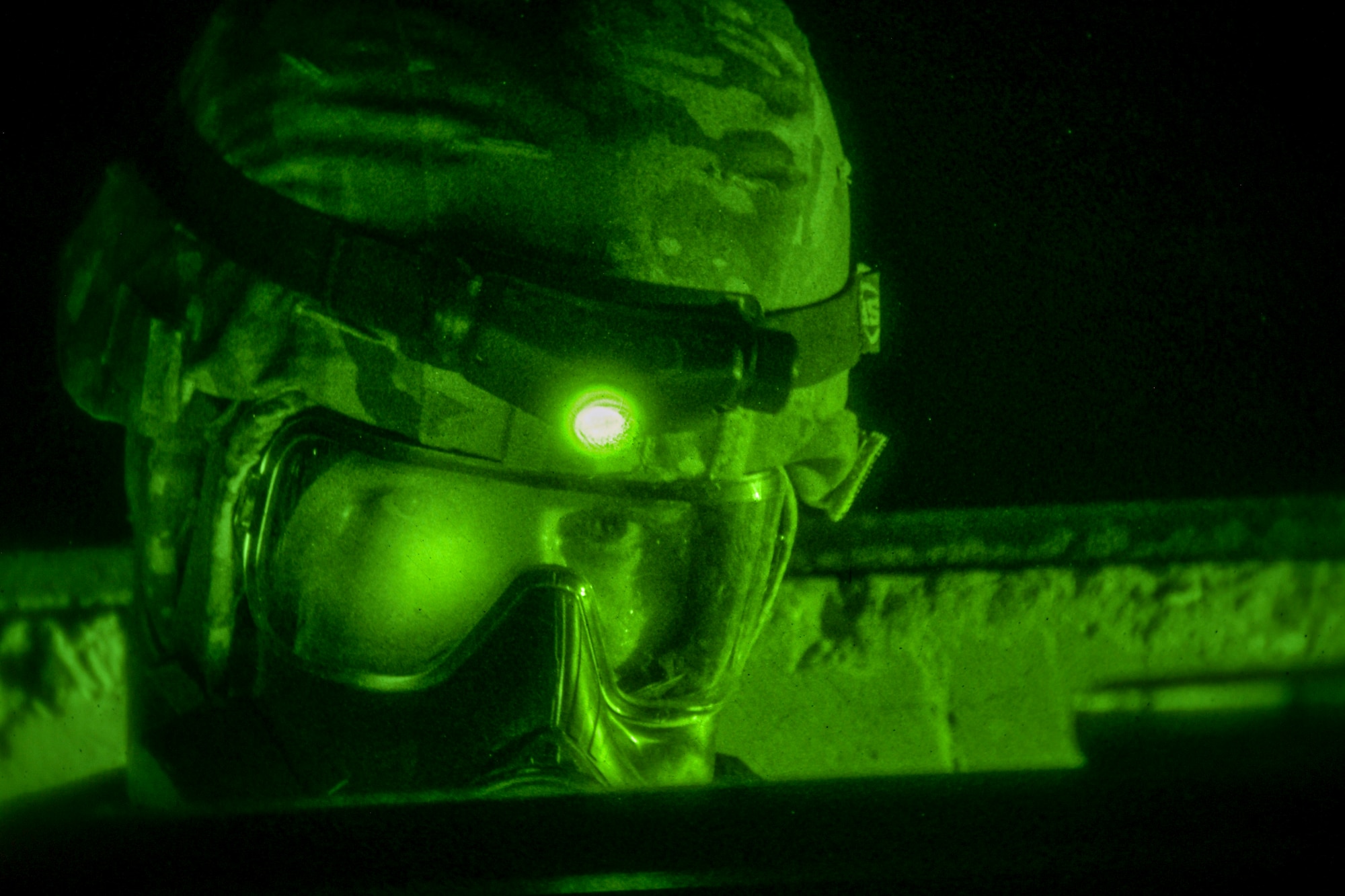 A 386th Airman in full MOPP gear and gas mask looks into the camera