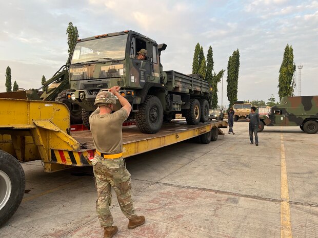 U.S. Army soldiers from 98th Support Maintenance Company, 17th Combat Sustainment Support Battalion, 11th Airborne Division, ground guide a tactical vehicle onto a flatbed trailer for commercial line haul following port operations at the port of Panjang, Indonesia, during Super Garuda Shield 25, August 14, 2025.