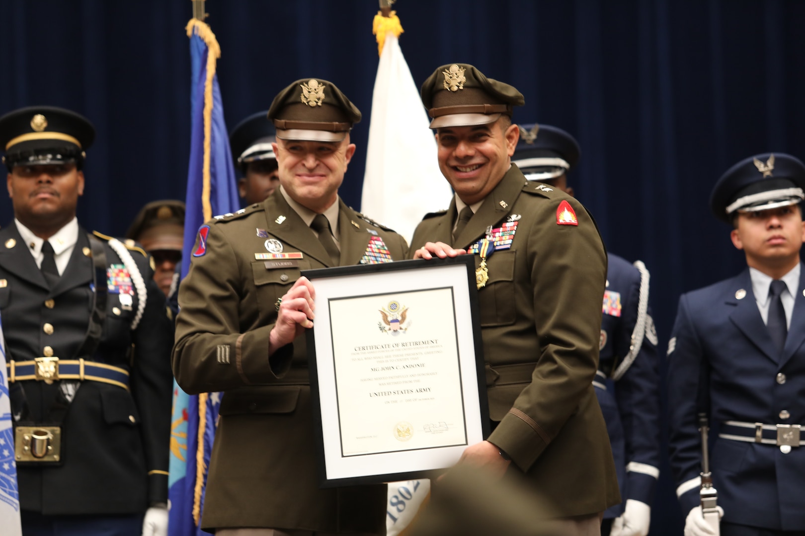U.S. Army Lt. Gen. Jonathan Stubbs, Director of the Army National Guard (left) presents a certificate of retirement to  U.S. Army Maj. Gen. John C. Andonie, outgoing commanding general (interim) for the D.C. National Guard, during a combined change of command and retirement ceremony Aug. 9, 2025, at DAR Constitution Hall. Andonie retired from the Air Force after 35 years of service.