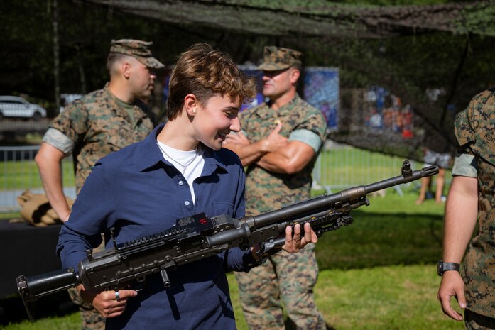 A Boston resident learns about the M240B machine gun at Boston Common during Marine Week Boston, Aug. 22, 2025. Marines display various equipment at the static display showcasing the Marine Corps capabilities to the public. In celebration of 250 years of proud tradition, Marines around the world unite to honor their shared heritage - a legacy defined by honor, courage, and commitment. (U.S. Marine Corps photo by Cpl. Vincent Needham)