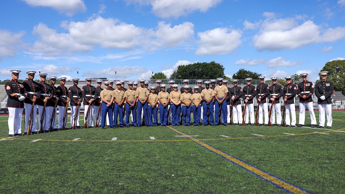U.S. Marines with the United States Marine Corps Silent Drill Platoon and members of the Lynn English High School Junior Reserve Officer Training Corps drill team pose for a photo during Marine Week Boston, Aug. 24, 2025. Marines with Marine Corps Recruiting Command share their traditions with local high schools in honor of the Corps’ 250th birthday. In celebration of 250 years of proud tradition, Marines around the world unite to honor their shared heritage - a legacy defined by honor, courage, and commitment. (U.S. Marine Corps photo by Sgt. Aidan Hekker)