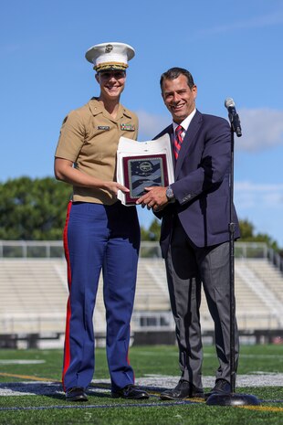 Jared C. Nicholson, right, the mayor of Lynn, Mass., presents a plaque and signed proclamation to Maj. Courtney Thompson, left, the commanding officer for Recruiting Station Boston, recognizing her efforts and the city’s support of the Marine Corps’ 250th birthday during Marine Week Boston, Aug. 24, 2025. Marines with Marine Corps Recruiting Command share their traditions with local high schools in honor of the Corps’ 250th birthday. In celebration of 250 years of proud tradition, Marines around the world unite to honor their shared heritage - a legacy defined by honor, courage, and commitment. (U.S. Marine Corps photo by Sgt. Aidan Hekker)