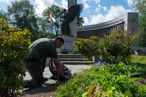 U.S. Marine Corps Gunnery Sgt. Benjamin Knight, a native of Hazen, N.D., an infantry unit leader assigned to Special Purpose Marine Air-Ground Task Force-250, pulls weeds at the World War II Memorial, Back Bay Fens park, during Marine Week Boston, Aug. 24, 2025. Marines stationed across the globe commemorate the 250th anniversary of the Marine Corps, honoring a distinguished legacy of service, sacrifice, and unwavering fidelity to both the nation and fellow Marines. (U.S. Marine Corps photo by Lance Cpl. Matthew A. McDonnell)
