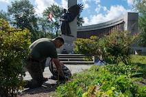 U.S. Marine Corps Gunnery Sgt. Benjamin Knight, a native of Hazen, N.D., an infantry unit leader assigned to Special Purpose Marine Air-Ground Task Force-250, pulls weeds at the World War II Memorial, Back Bay Fens park, during Marine Week Boston, Aug. 24, 2025. Marines stationed across the globe commemorate the 250th anniversary of the Marine Corps, honoring a distinguished legacy of service, sacrifice, and unwavering fidelity to both the nation and fellow Marines. (U.S. Marine Corps photo by Lance Cpl. Matthew A. McDonnell)