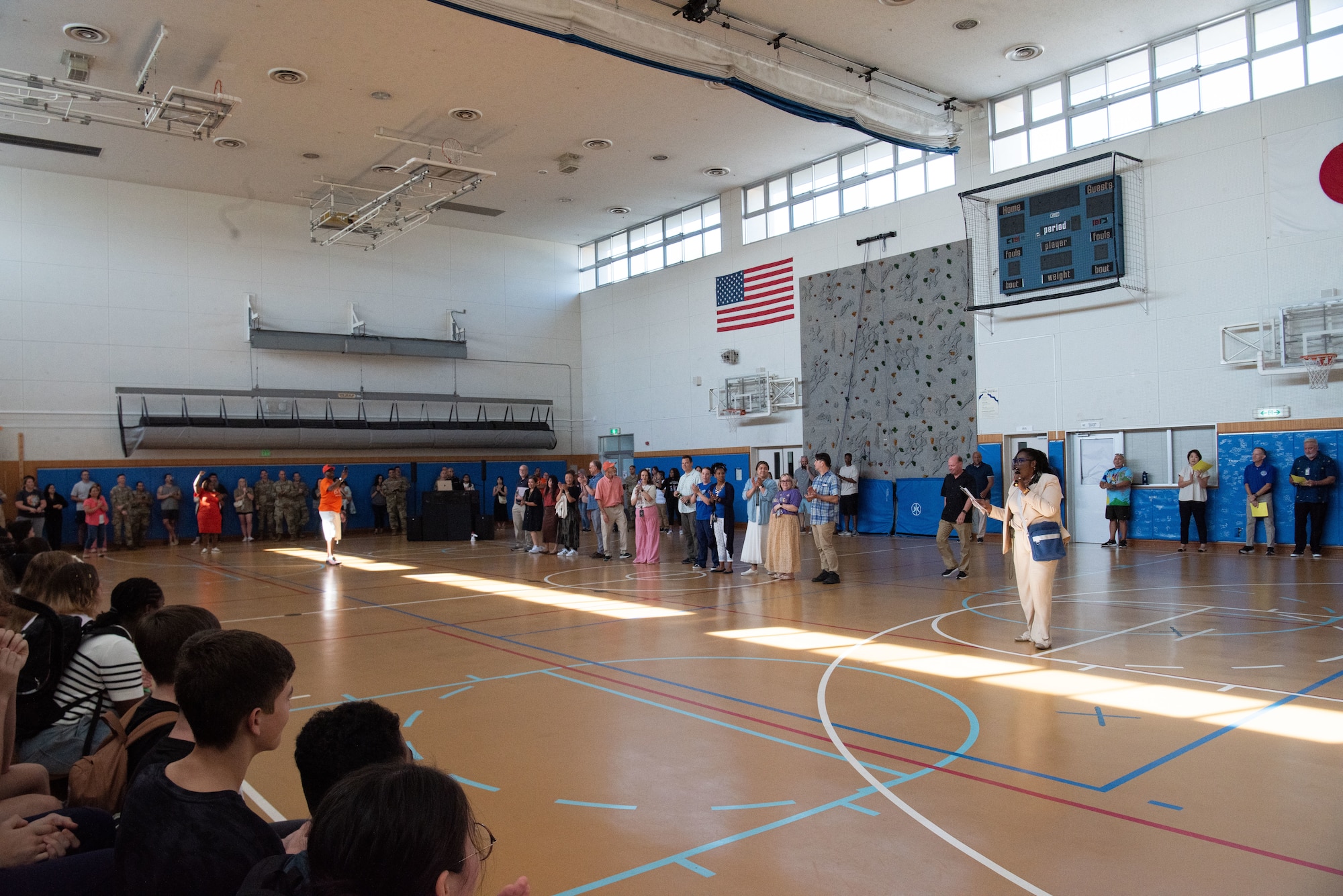 People gather in a school gymnasium.