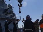 Sailors aboard the Arleigh Burke-class guided-missile destroyer USS Higgins (DDG 76) simulate loading ammunition from a barge during Noble Prime 25-3 in the Cleveland Bay, Australia, July 28.