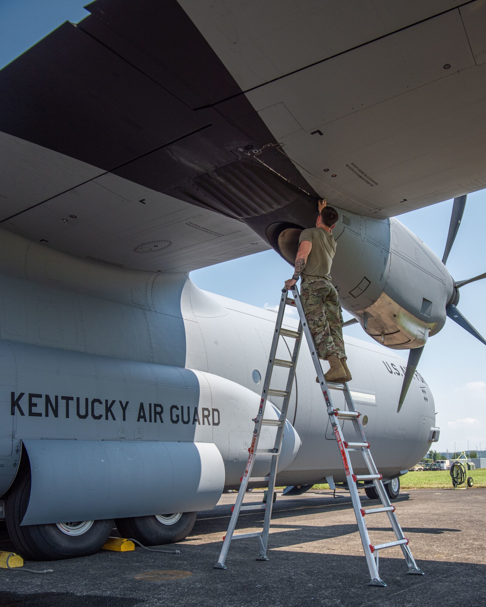 A U.S. servicemember inspects the propeller of an aircraft.