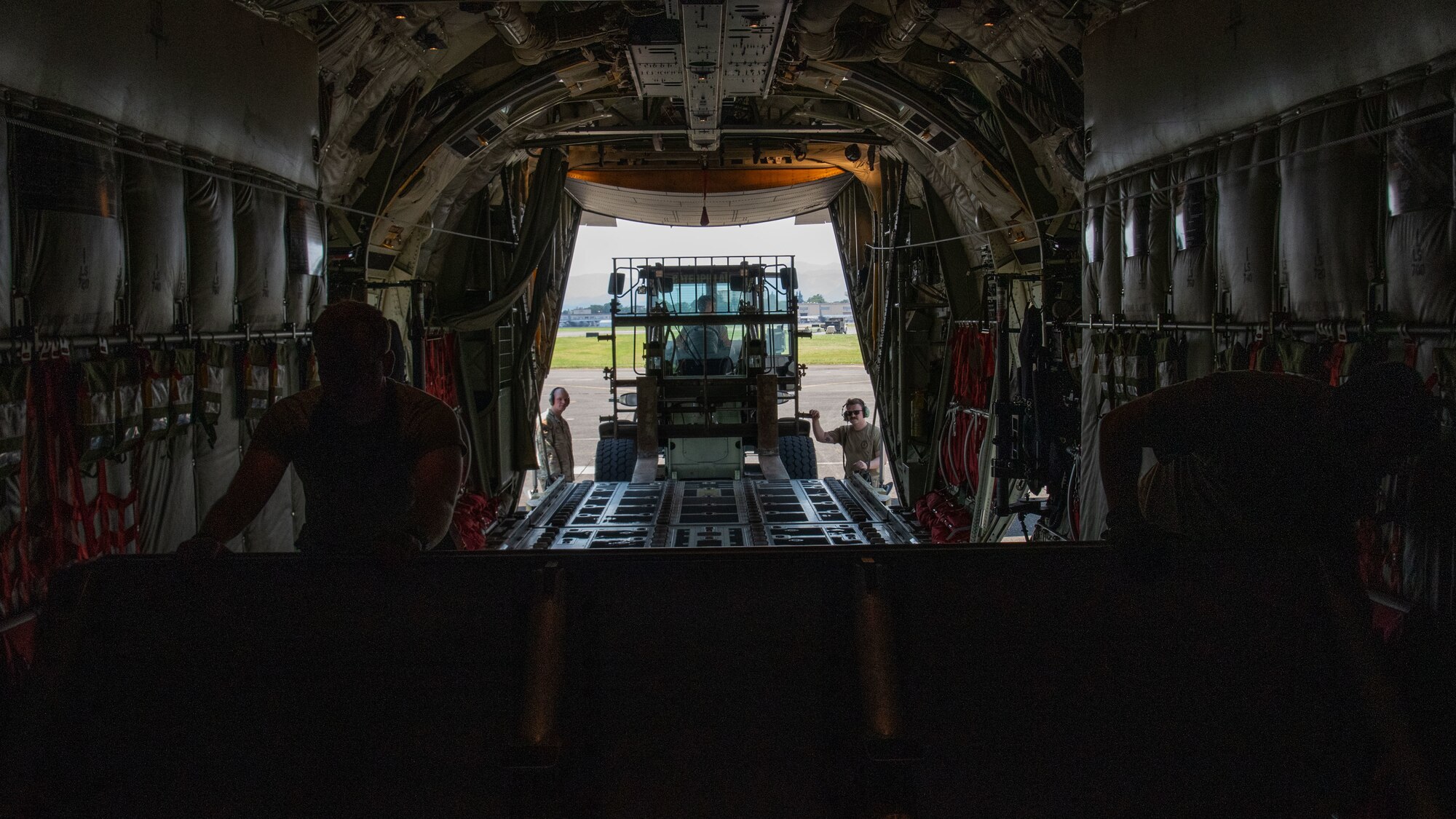 U.S. servicemembers load a barricade into the rear of an aircraft.