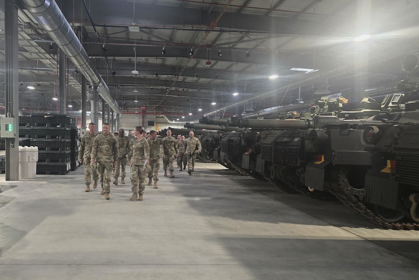 Army Lt. Col. Michelle McDevitt, the commander of Army Field Support Battalion-Poland, (front right) leads a group of top leaders from the 3rd Infantry Division Sustainment Brigade and the 1st Armored Division Sustainment Brigade through one of the facilities at the Powidz Army Prepositioned Stocks-2 worksite August 18, 2025, while speaking with the 3rd ID DSB commander, Col. Aaron Becker. (U.S. Army courtesy photo)