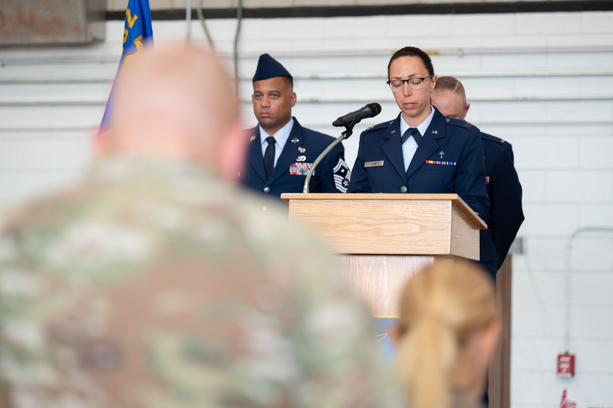 Chaplain speaks into a microphone at a podium.