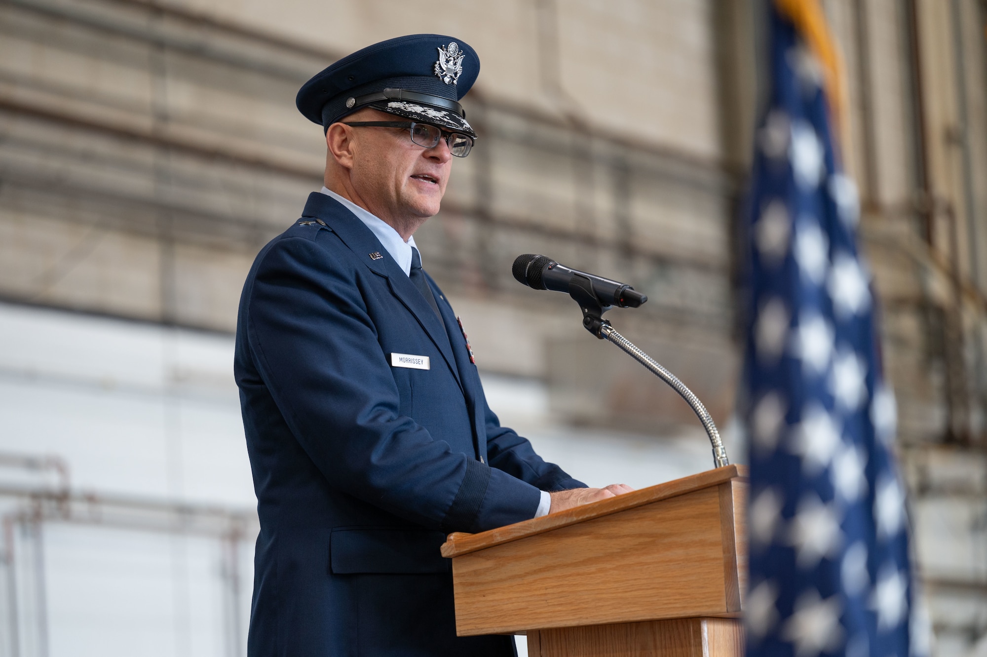 Airman speaks into a microphone at a podium.