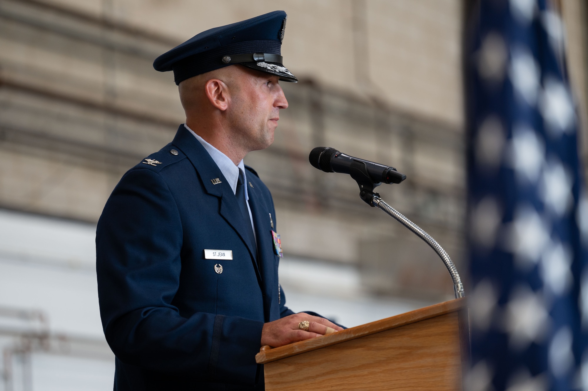 Airman speaks into a microphone at a podium.
