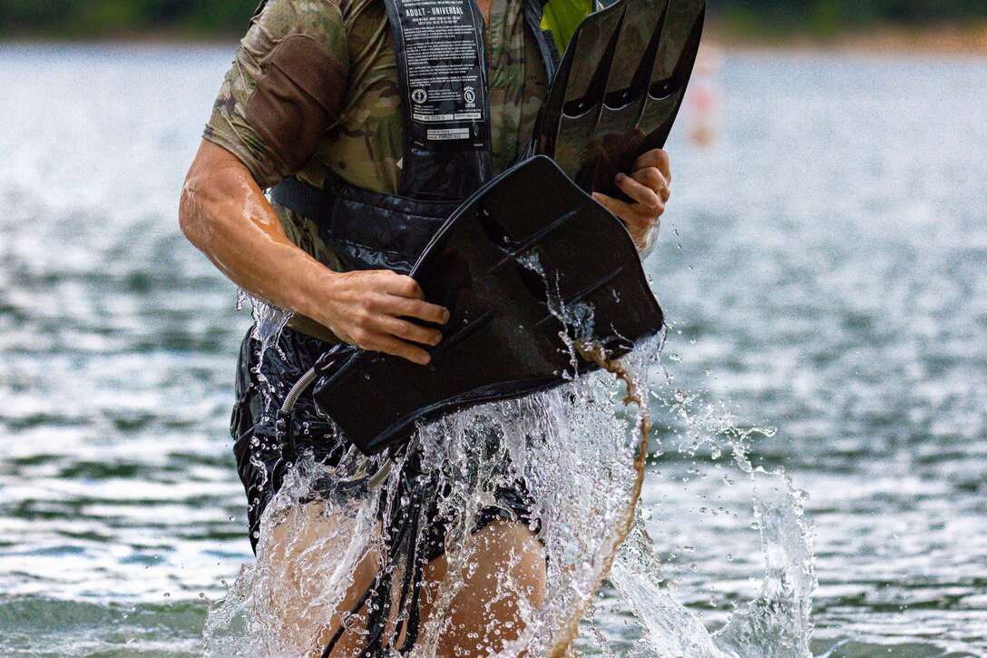 A man emerges from a lake.