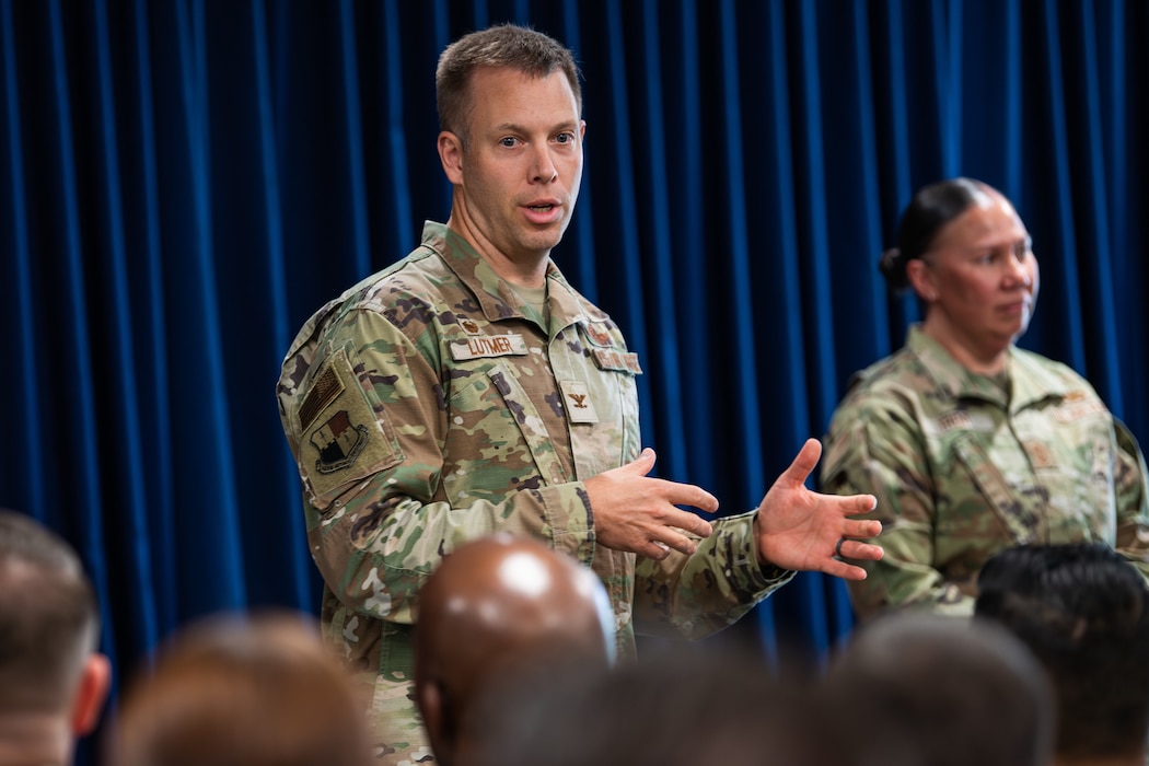 An Air Force colonel speaks to a room full of Airmen