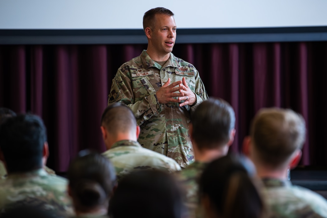 An Air Force colonel speaks to a room full of Airman