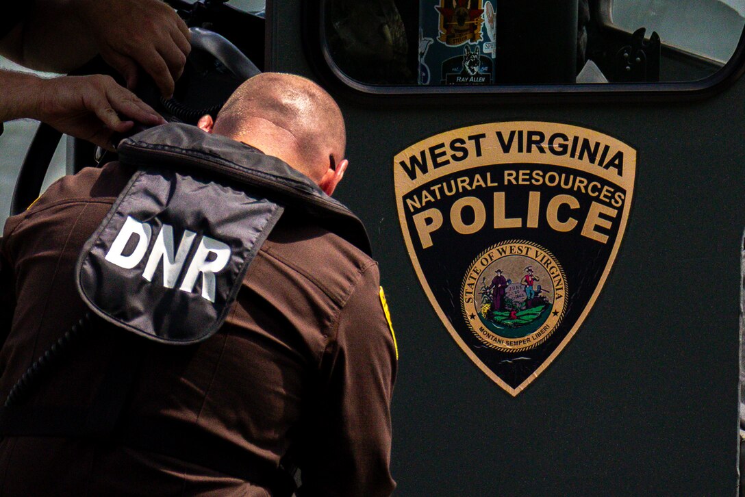 A man sits on a speedboat on a lake.