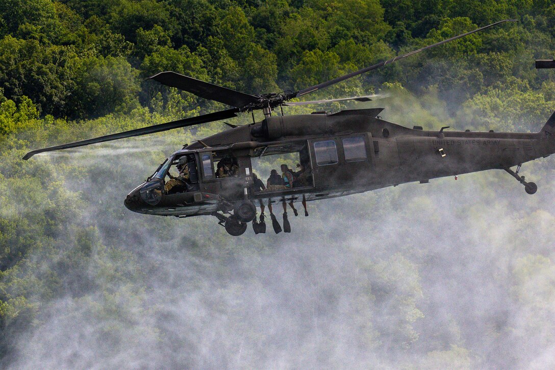 A helicopter hovers above a lake.