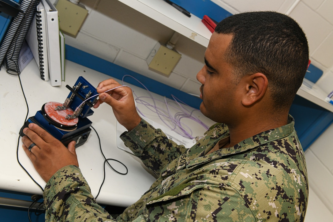JACKSONVILLE, Fla. (June 12, 2024)
Aviation Electronics Technician 2nd Class Jaedon Richardson, assigned to Fleet Readiness Center Southeast Detachment Jacksonville, attaches a fiber optic segment to the automatic polisher for final polish before inspection and test. Detachment Jacksonville was recently certified to repair fiber optics. (U.S. Navy Photo by Toiete Jackson)