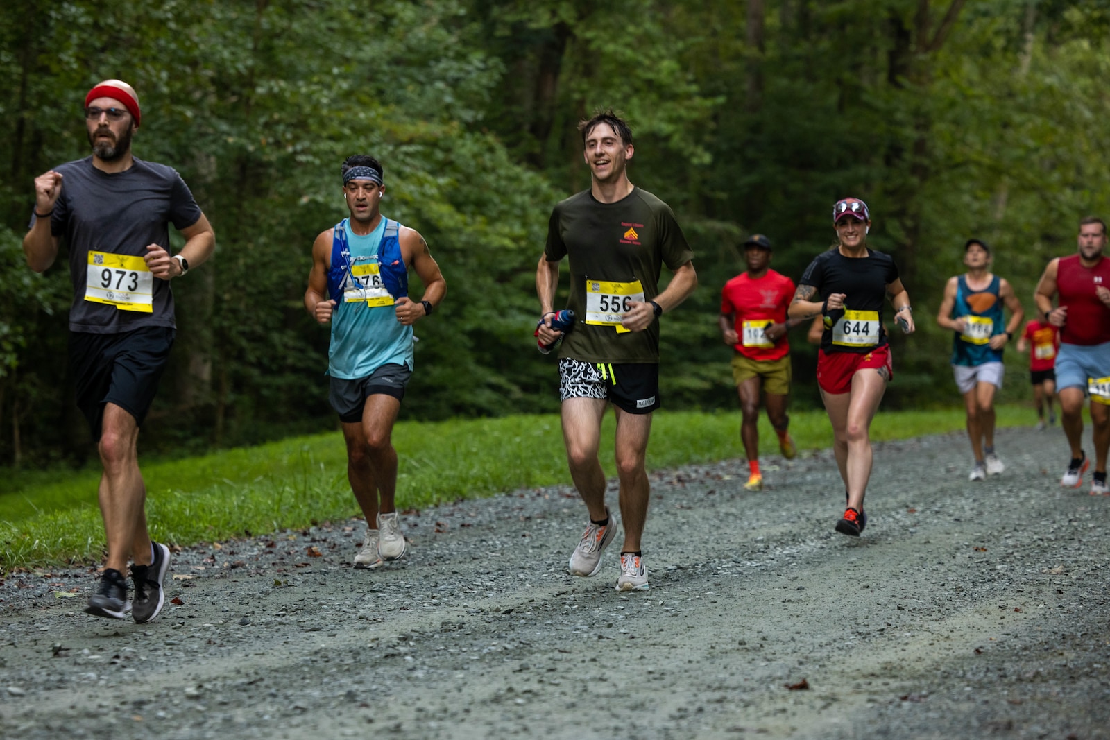 Participants run in the Quantico 12K on Marine Corps Base Quantico, Virginia, Aug. 23, 2025. The event challenges runners and their individual tenacity as they ran 7.46 miles of trails through the woods of Marine Corps Base Quantico's Officer Candidate School. (U.S. Marine Corps photo by Lance Cpl. Federico Marquez)