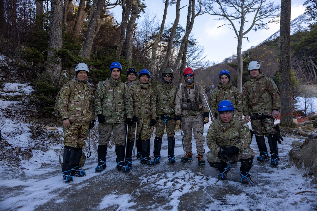 U.S. Navy Hospital Corpsman 2nd Class. Tyler Neils, a Corpsman with the Mountain Warfare Training Center, poses with for photo with Argentine Marines members of the Battalion Infantria de Marine no. 5, before a hike up a mountain during a cold weather exercise in Ushuaia, Argentina, Aug. 12, 2025. This training creates opportunities for continued combined exercises with Argentine forces which aim to build upon the skills learned in these knowledge exchanges. (U.S. Marine Corps photo by Lance Cpl. Payton Goodrich)