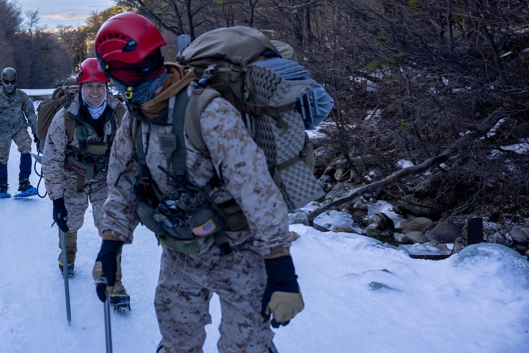 U.S. Marine Corps 1st Lt. Damon Crossland, and U.S. Navy Hospital Corpsman 2nd Class. Tyler Neils, a Corpsman with the Mountain Warfare Training Center hike up a mountain during a cold weather exercise in Ushuaia, Argentina, Aug. 12, 2025. This training creates opportunities for continued combined exercises with Argentine forces which aim to build upon the skills learned in these knowledge exchanges. (U.S. Marine Corps photo by Lance Cpl. Payton Goodrich)