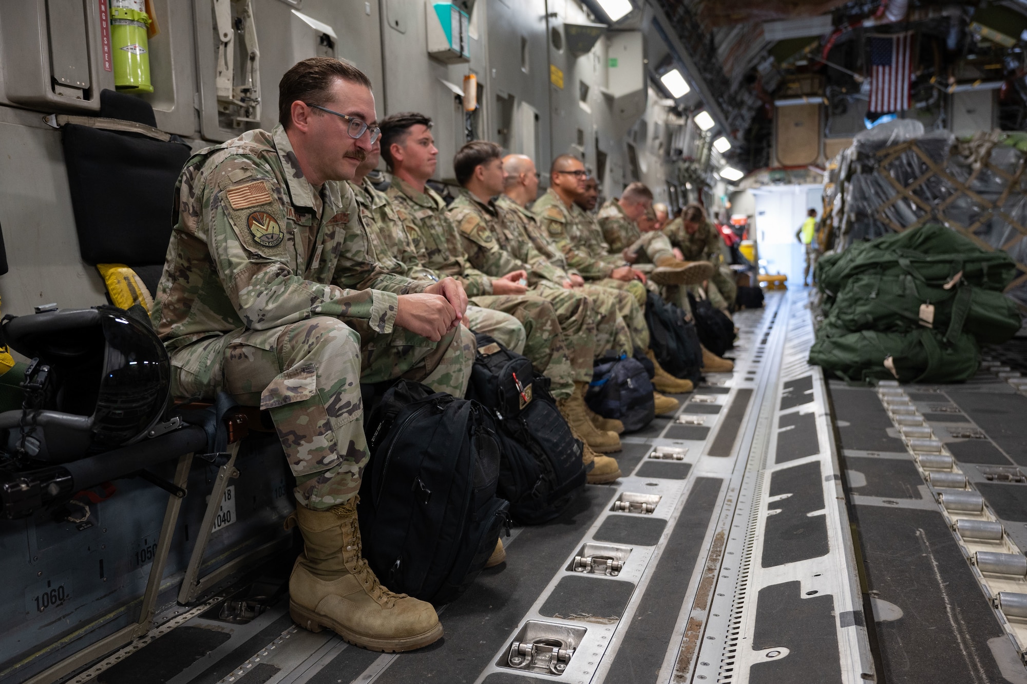 Airmen sit in an aircraft.