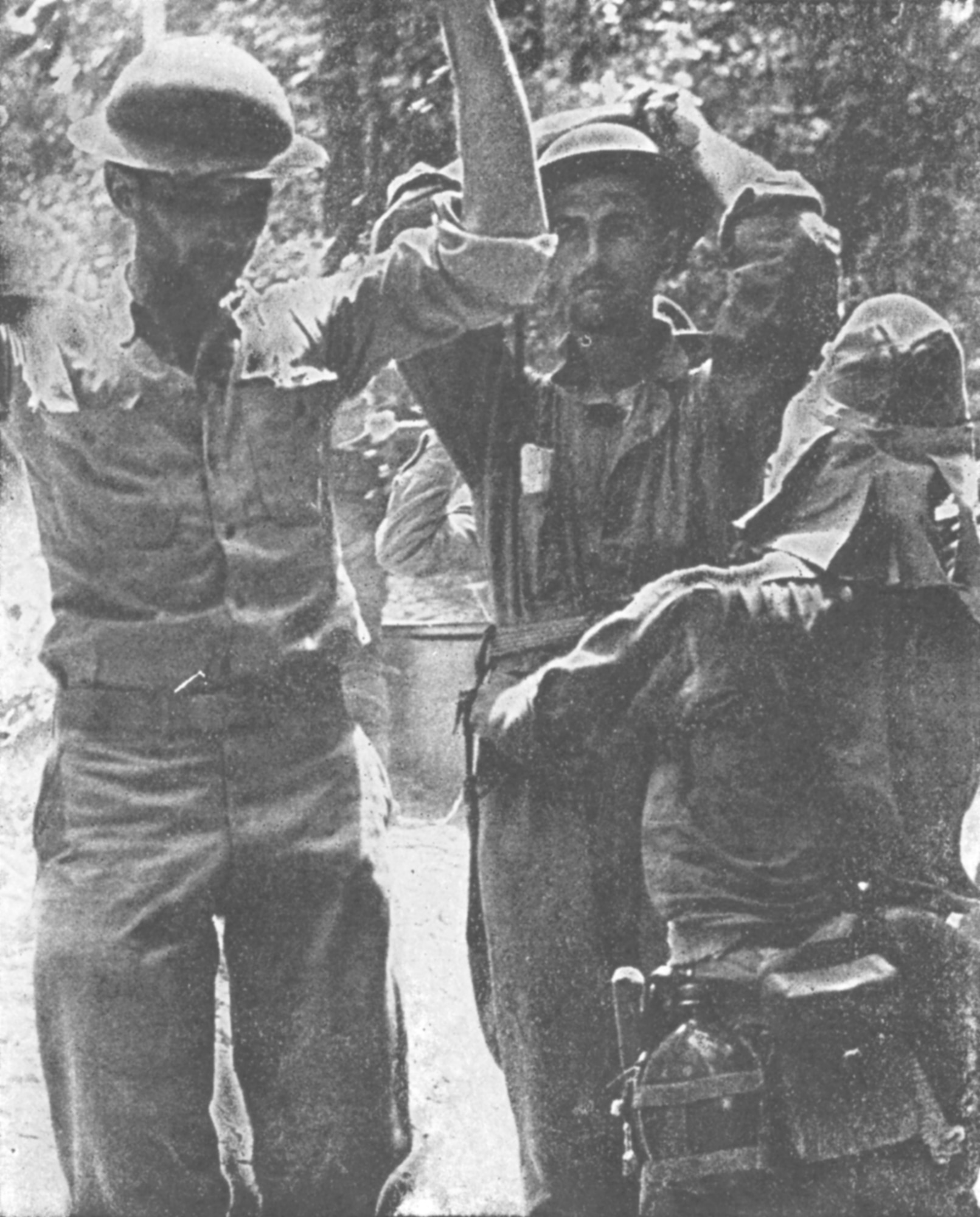 Two soldiers with the arms up in the air surrenders to a Japanese soldier.